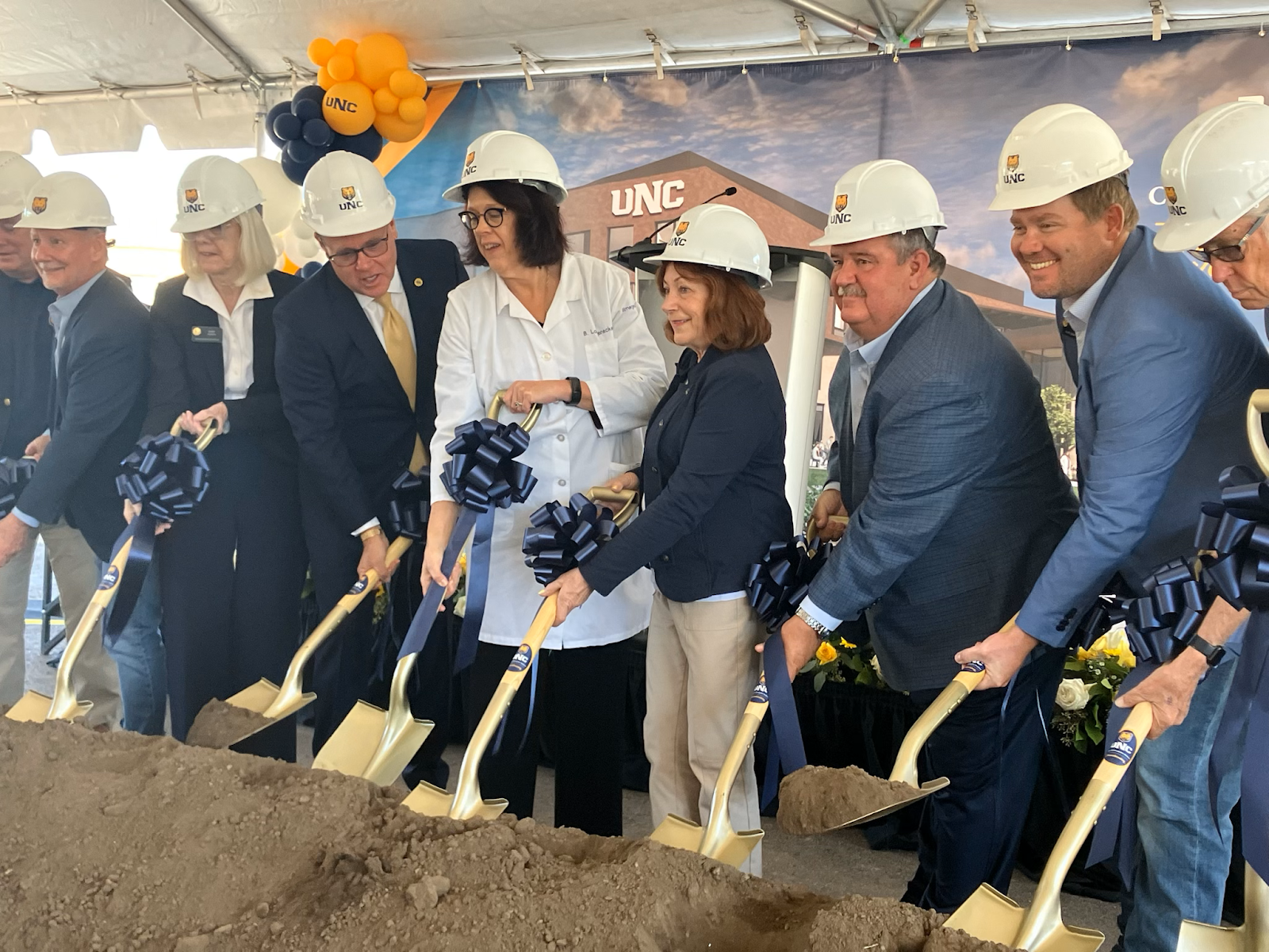 Lt. Governor and others wearing hardhats and holding shovels at a groundbreaking ceremony.