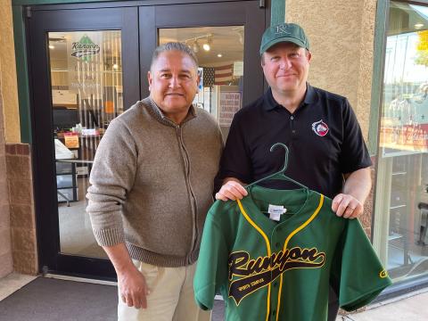 Governor Polis holding a Runyon jersey.